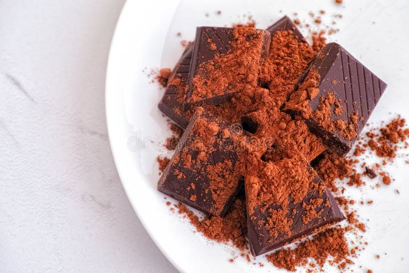 Broken Dark Chocolate with Cocoa Powder on a Plate Stock Photo Image