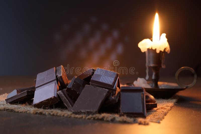 Broken dark sweet chocolate on a stone table close up wooden royalty-vrije stock afbeelding