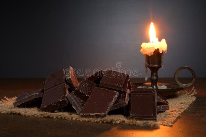 Broken dark sweet chocolate on a stone table close up wooden royalty-vrije stock fotografie