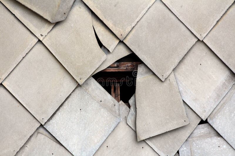 Broken destroyed office building wall covered with protective tiles revealing wooden support frame stock image