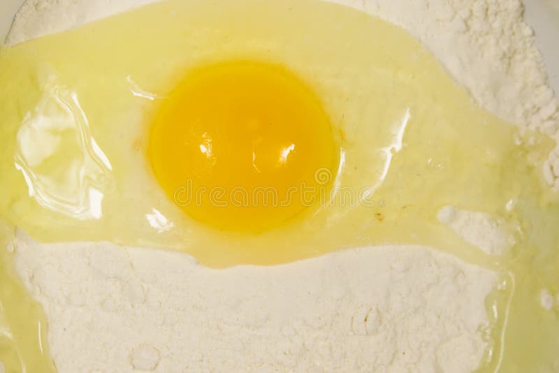 Broken egg on flour close-up royalty free stock image