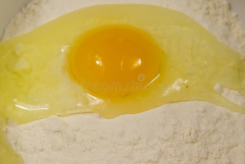 Broken egg on flour close-up royalty free stock images