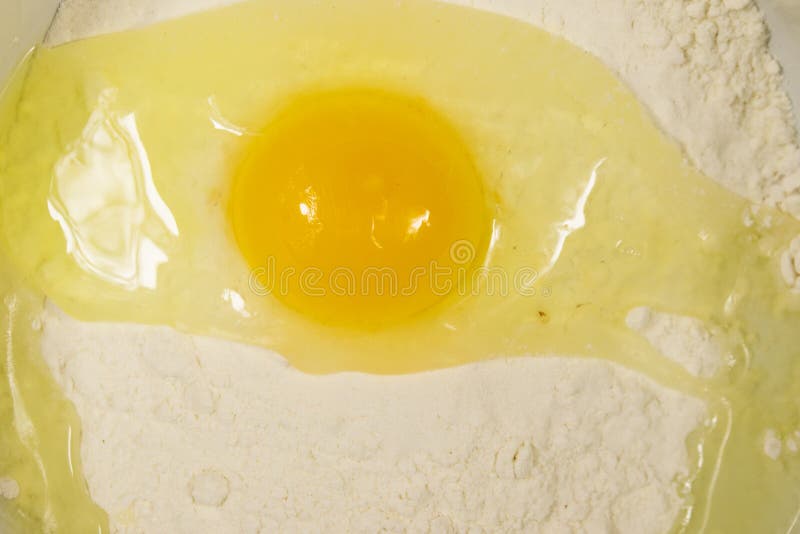 Broken egg on flour close-up royalty free stock photo