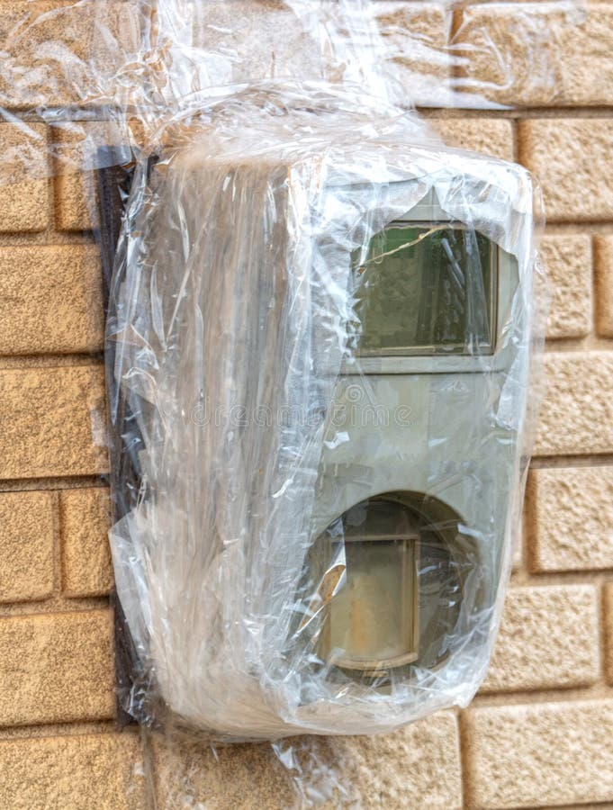 Broken Electric Meter Wrapped in Duct Tape on the Wall Stock Photo