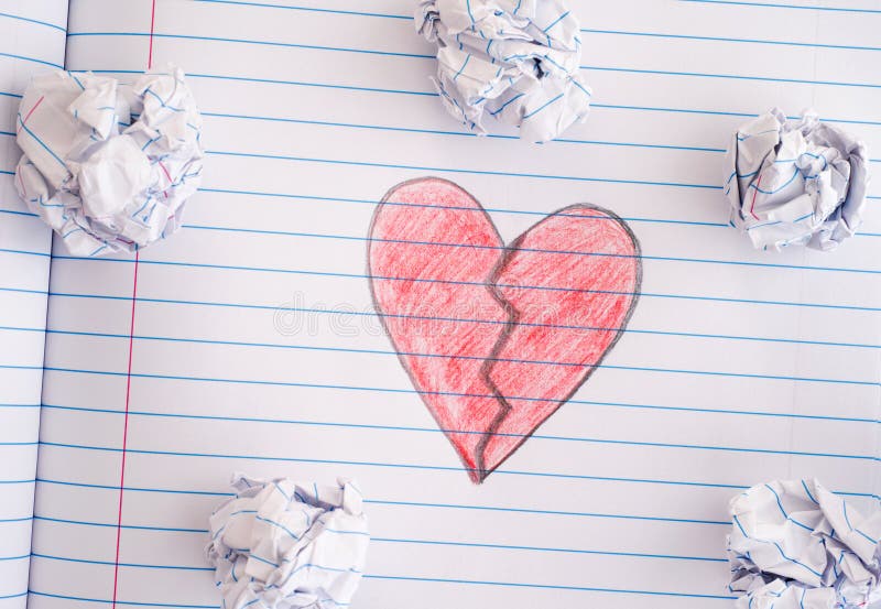Broken Heart on notebook sheet with some crumpled paper balls on stock image Broken Heart on notebook sheet with some crumpled paper balls on stock image