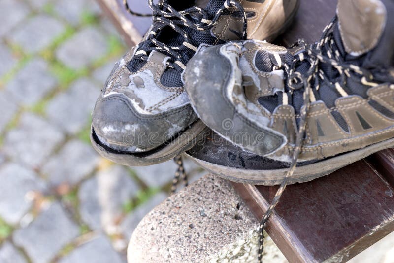 Broken Hiking Boots after the Autumn Hike on the Bench Stock Photo