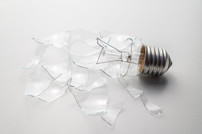 Broken light bulb, on white surface. stock photo