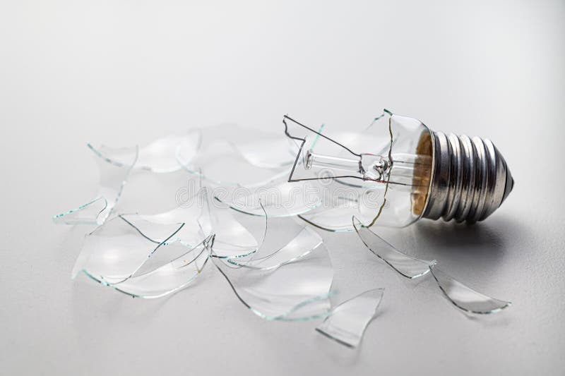 Broken light bulb, on white surface. royalty free stock images