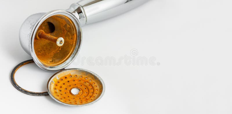 Broken rust-eaten shower head with limescale and rust stains on it. Hard water concept. Broken plumbing fixture. royalty free stock photography