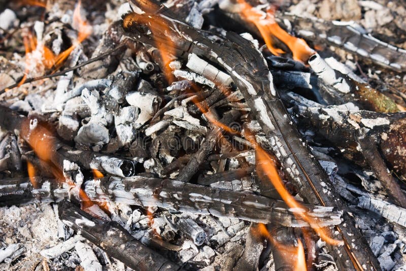 Scattered broken smoldering bonfire with flame top horizontal view