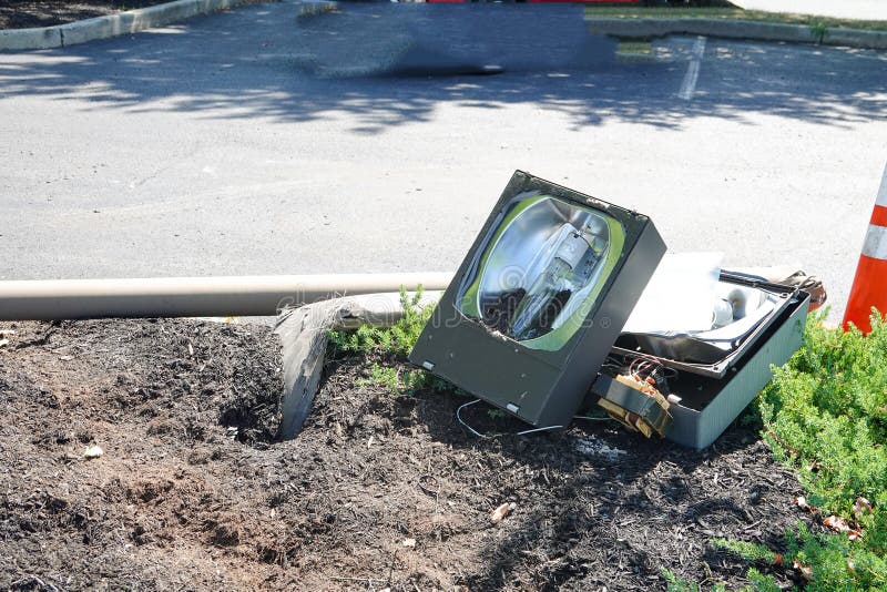 Broken Street Light Laying on the Ground in a Parking Lot Stock Image