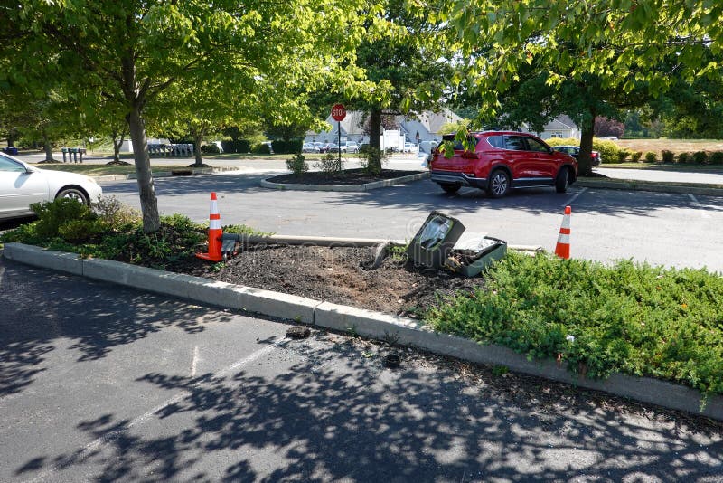 A Broken Street Light Lays on the Ground with Orange Warning Cones