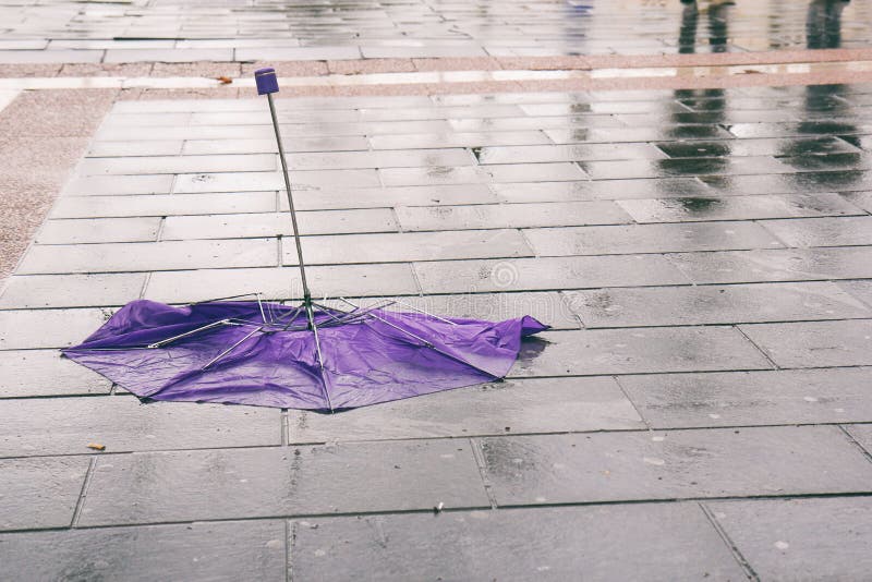 Broken umbrella on wet sidewalk stock image Broken umbrella on wet sidewalk stock image