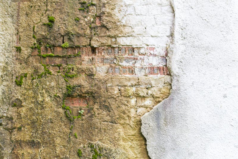 Broken vintage bricklaying wall fragment from old red clay bricks and damaged plaster frame background texture