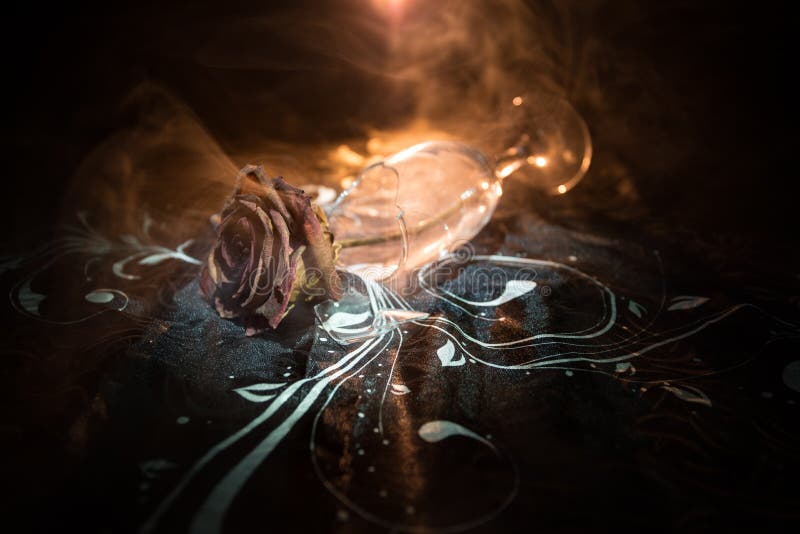Broken wineglass and wilted rose on dark background. A wilting rose signifies lost love, divorce, or a bad relationship, dead rose stock images Broken wineglass and wilted rose on dark background. A wilting rose signifies lost love, divorce, or a bad relationship, dead rose stock images