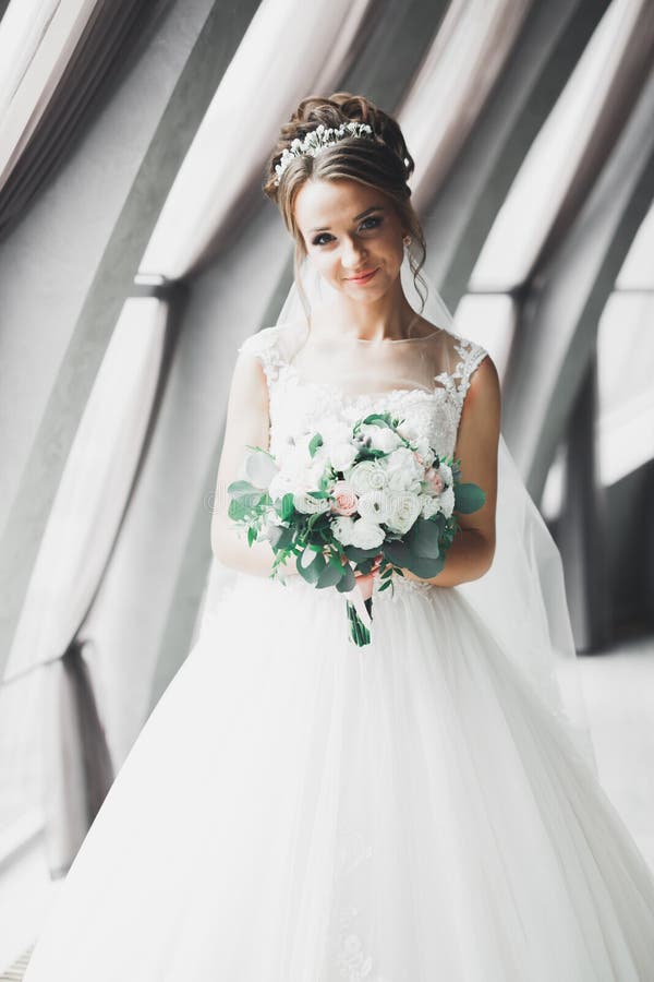 Bruden håller en stor och vacker brudbukett med blommor arkivfoto