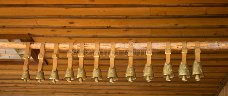 Bronze bells in a row hanging in a wooden cabin. Traditional big metal pot stock images, royalty-free photos and pictures