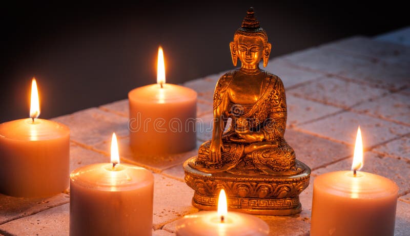 Bronze-Buddha mit warmen brennenden Kerzen über Kalksteinhintergrund