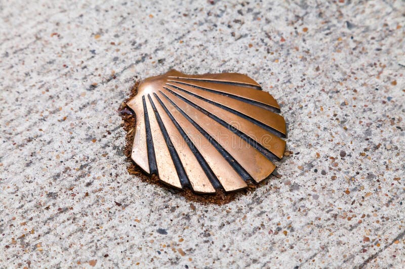 A bronze shell embedded in a textured stone pathway at a historic pilgrimage site royalty free stock photos