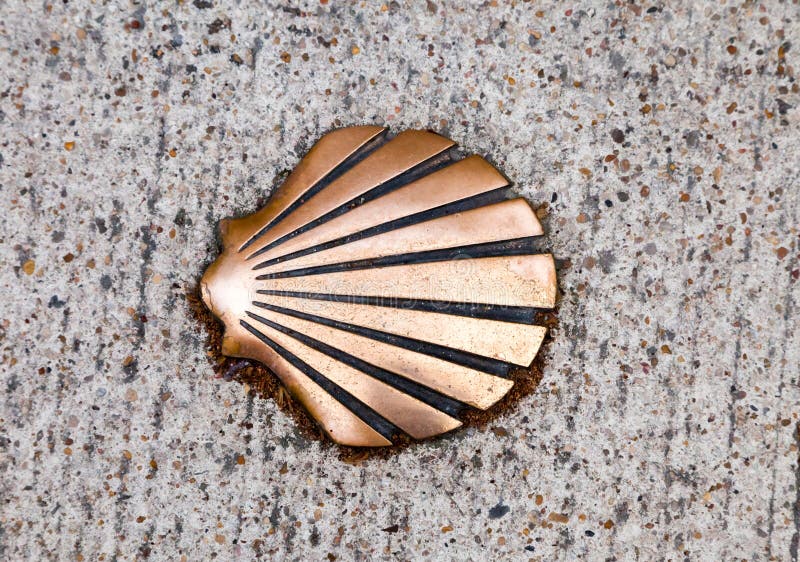 A bronze shell embedded in a textured stone pathway at a historic pilgrimage site royalty free stock photography
