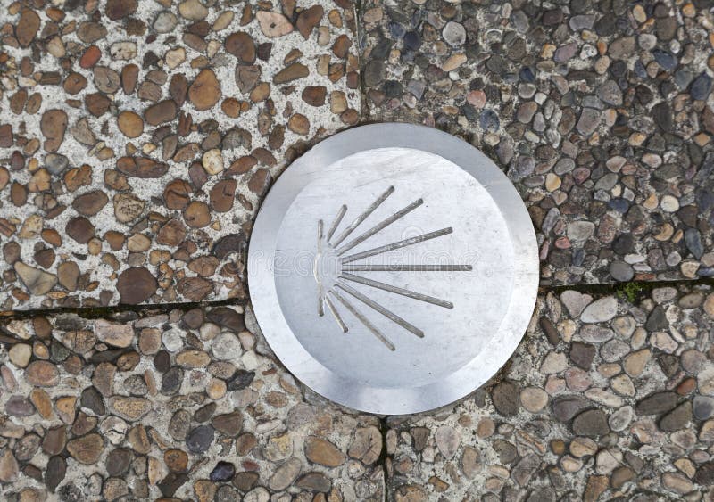 A bronze shell embedded in a textured stone pathway at a historic pilgrimage site royalty free stock photo