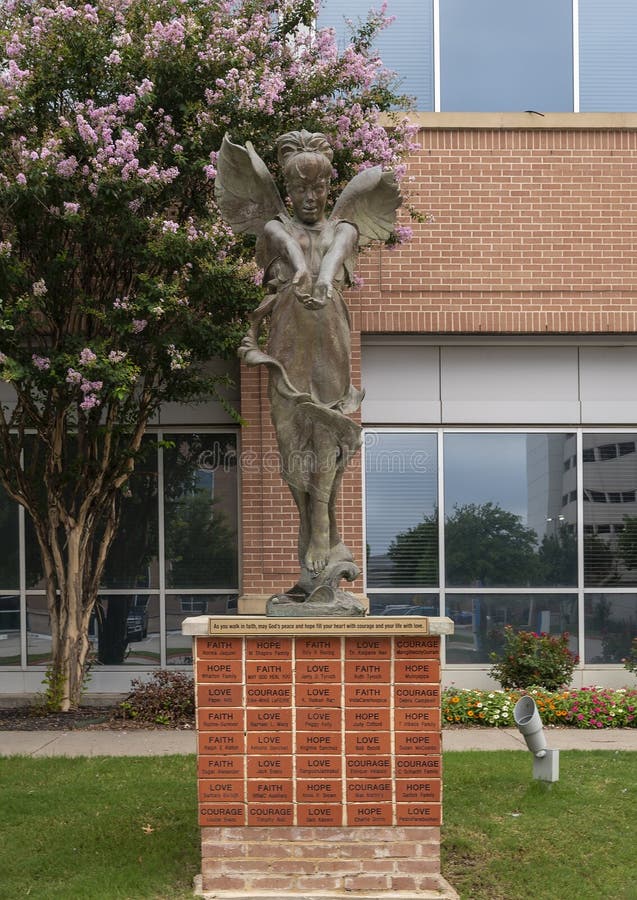 Bronzen beeld van een jong vrouwtje met engel vleugels buiten het centrum voor de kanker van de methodist richardson in texas.