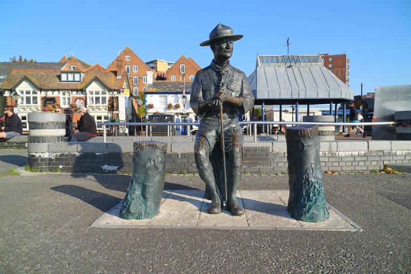 Bronzestatue, die auf Ausflugbootskai sitzt