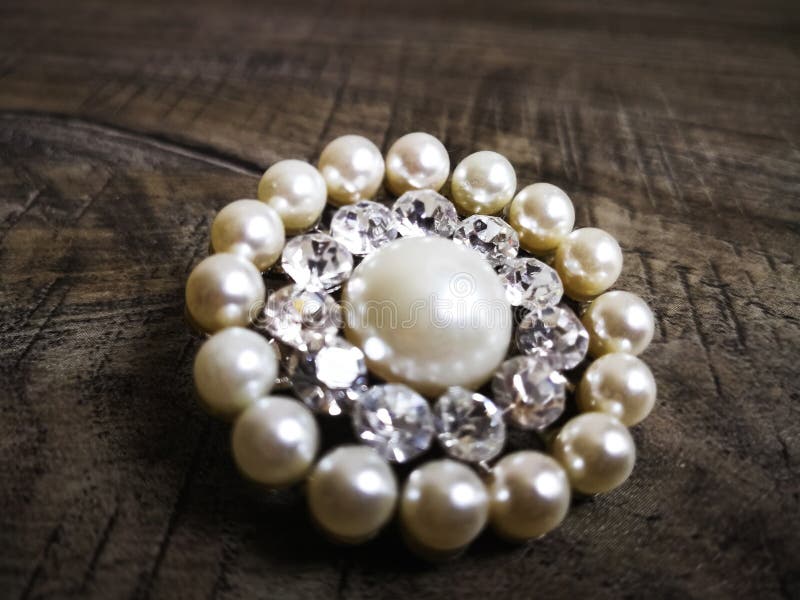 Brooch met witte parel voor kleding geïsoleerd op houten achtergrond Brooch met diamantsteen Oud kostbaar broedsel royalty-vrije stock foto's Brooch met witte parel voor kleding geïsoleerd op houten achtergrond Brooch met diamantsteen Oud kostbaar broedsel royalty-vrije stock foto's
