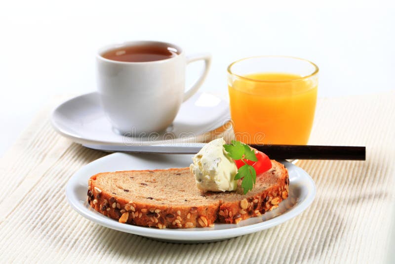 Brood met uitgespreide kaas, kop thee en jus d'orange royalty-vrije stock foto's Brood met uitgespreide kaas, kop thee en jus d'orange royalty-vrije stock foto's