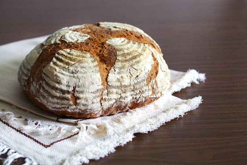Brood van artisanaal die roggebrood, met bloem, op een lijstdoek wordt bestrooid royalty-vrije stock foto's Brood van artisanaal die roggebrood, met bloem, op een lijstdoek wordt bestrooid royalty-vrije stock foto's