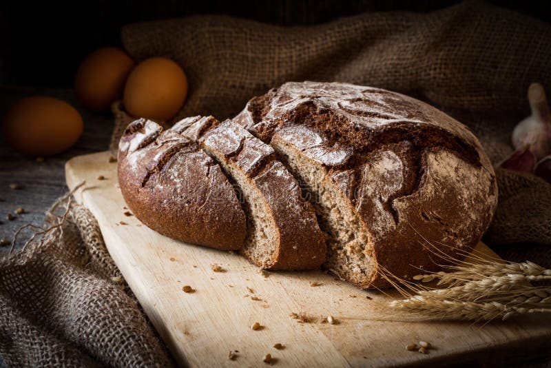 Brood van brood op houten scherpe raad wordt gesneden die stock foto's Brood van brood op houten scherpe raad wordt gesneden die stock foto's