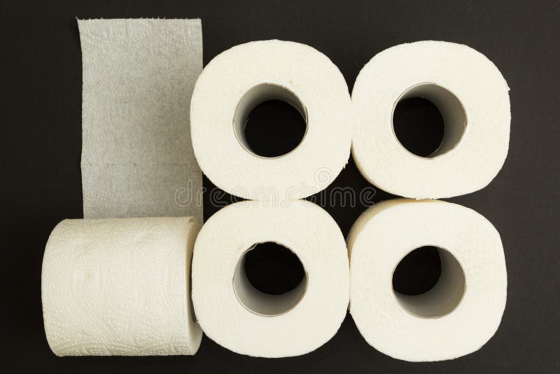 Broodjes van wit toiletpapier op een zwarte achtergrond, concept royalty-vrije stock foto Broodjes van wit toiletpapier op een zwarte achtergrond, concept royalty-vrije stock foto