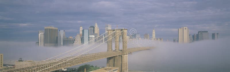 Brooklyn Bridge in fog with New York skyline