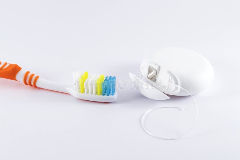 Brosse à dents et fil dentaire sur le fond blanc photographie stock libre de droits Brosse à dents et fil dentaire sur le fond blanc photographie stock libre de droits