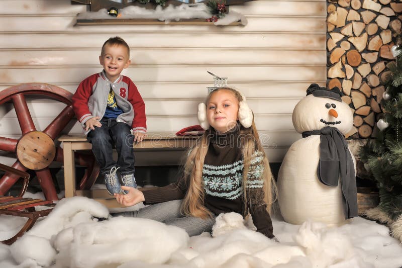 Brother and sister in front of the house in winter