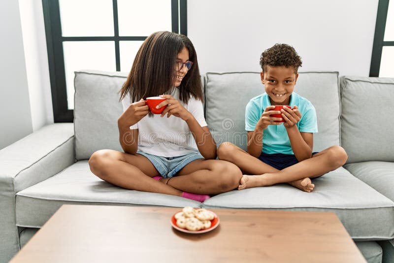 Brother and Sister Having Breakfast Sitting on Sofa at Home Stock Image
