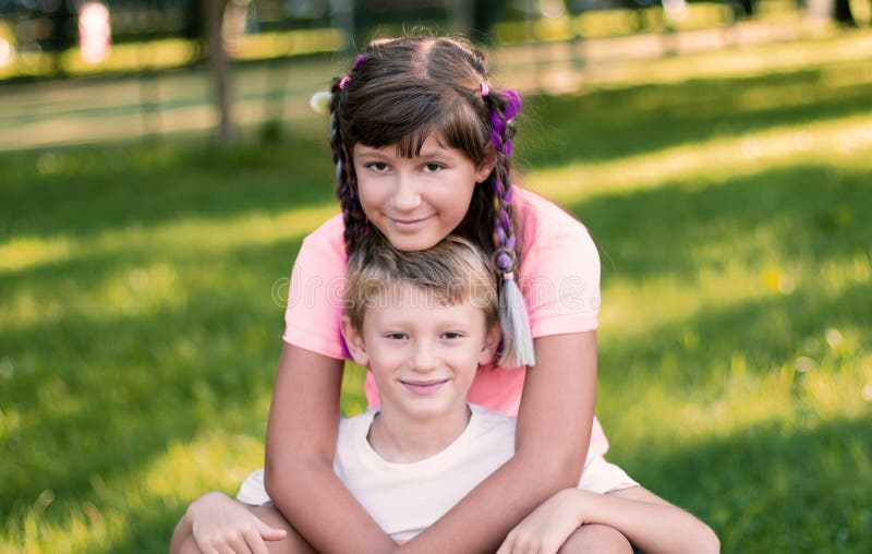 Brother and sister are having fun together at park stock photo