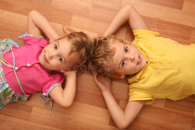Brother and sister lie on floor