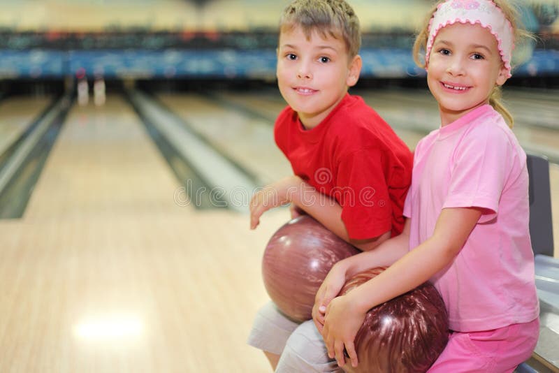 Brother and sister sit in bowling club stock photography