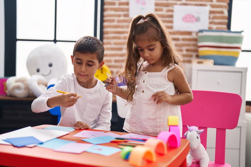 Brother and Sister Students Sitting on Table Drawing on Paper at