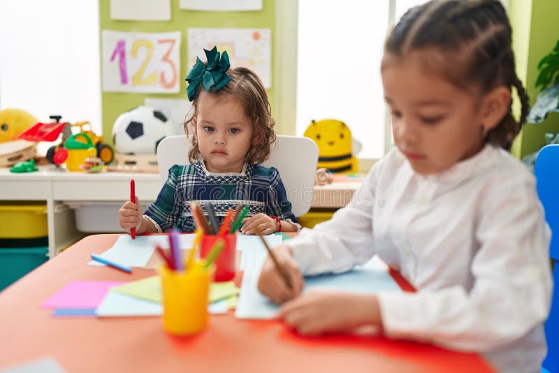 Brother and Sister Students Sitting on Table Drawing on Paper at