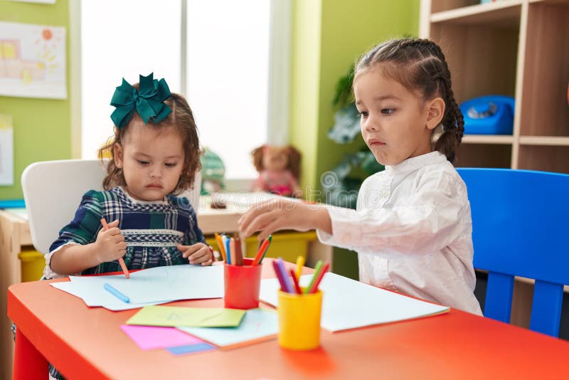 Brother and Sister Students Sitting on Table Drawing on Paper at