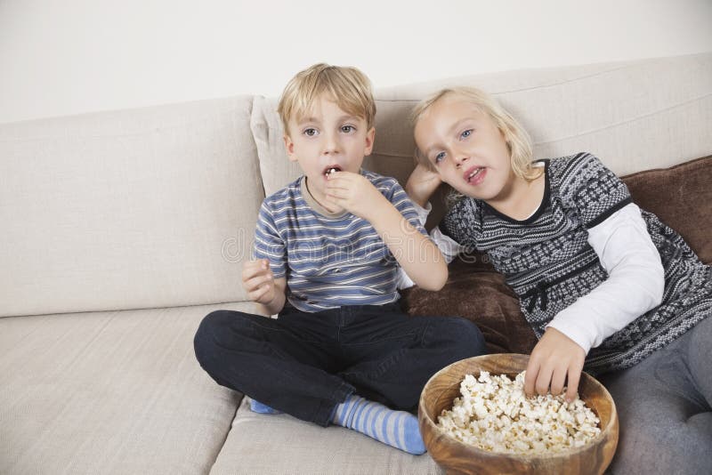 Brother and Sister Watching TV and Eating Popcorn Stock Photo Image