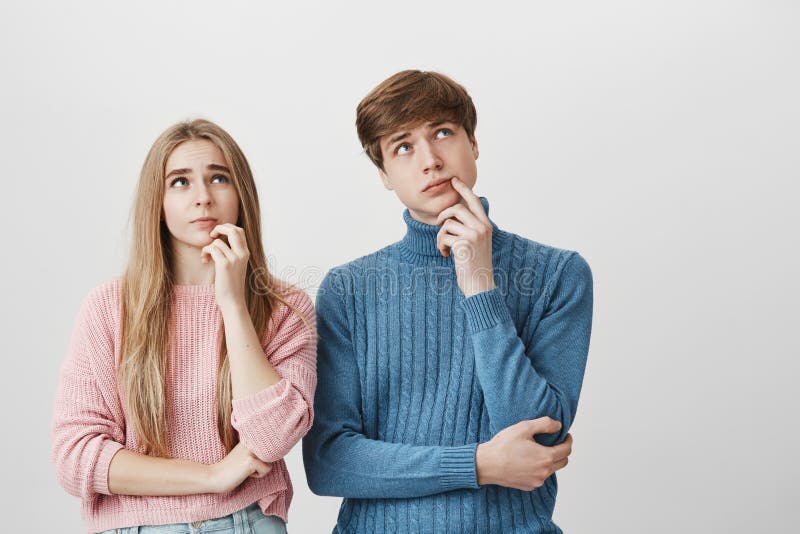 Brother y hermana que se colocan cerca de uno a que tiene expresiones pensativas que intentan encontrar la solución, mirando haci fotos de archivo Brother y hermana que se colocan cerca de uno a que tiene expresiones pensativas que intentan encontrar la solución, mirando haci fotos de archivo