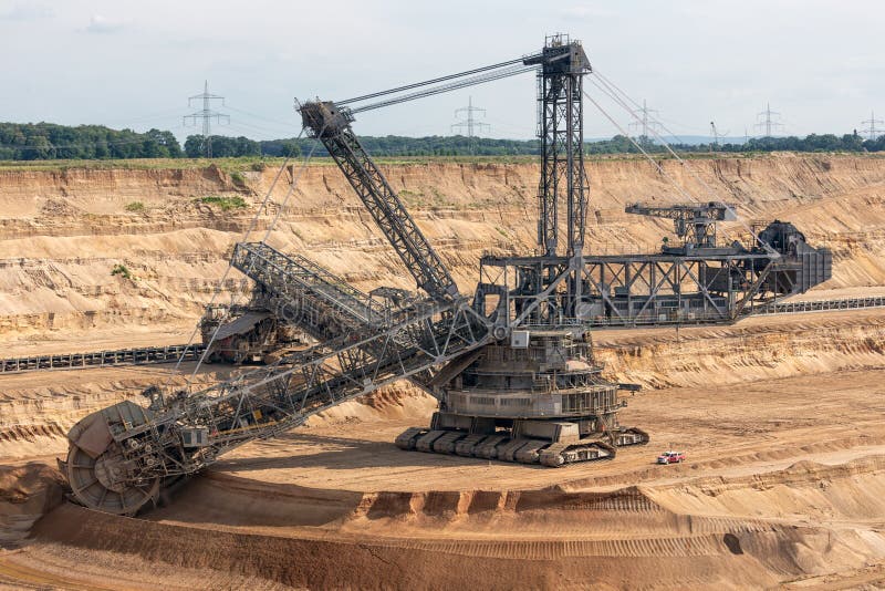 Brown coal open pit landscape with digging excavator in Germany royalty free stock photos