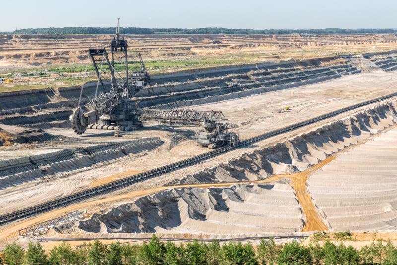 Brown coal open pit landscape with digging excavator in Germany royalty free stock photos