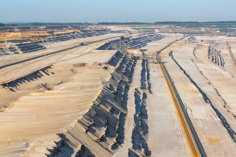 Brown coal open pit landscape with digging excavator in Germany royalty free stock photography