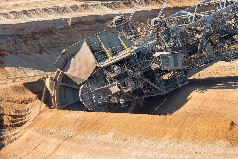 Brown coal open pit landscape with digging excavators in Germany royalty free stock photo