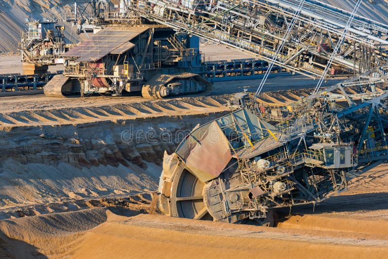 Brown coal open pit landscape with digging excavators in Germany stock image