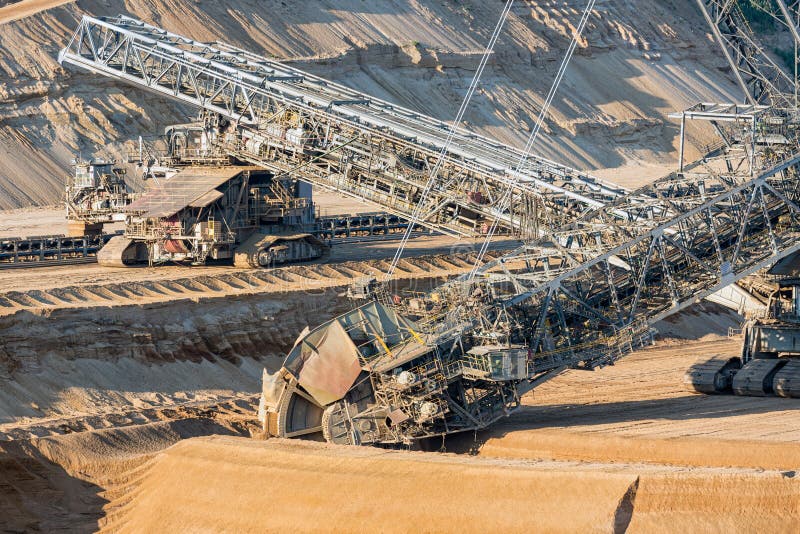 Brown coal open pit landscape with digging excavators in Germany royalty free stock photography